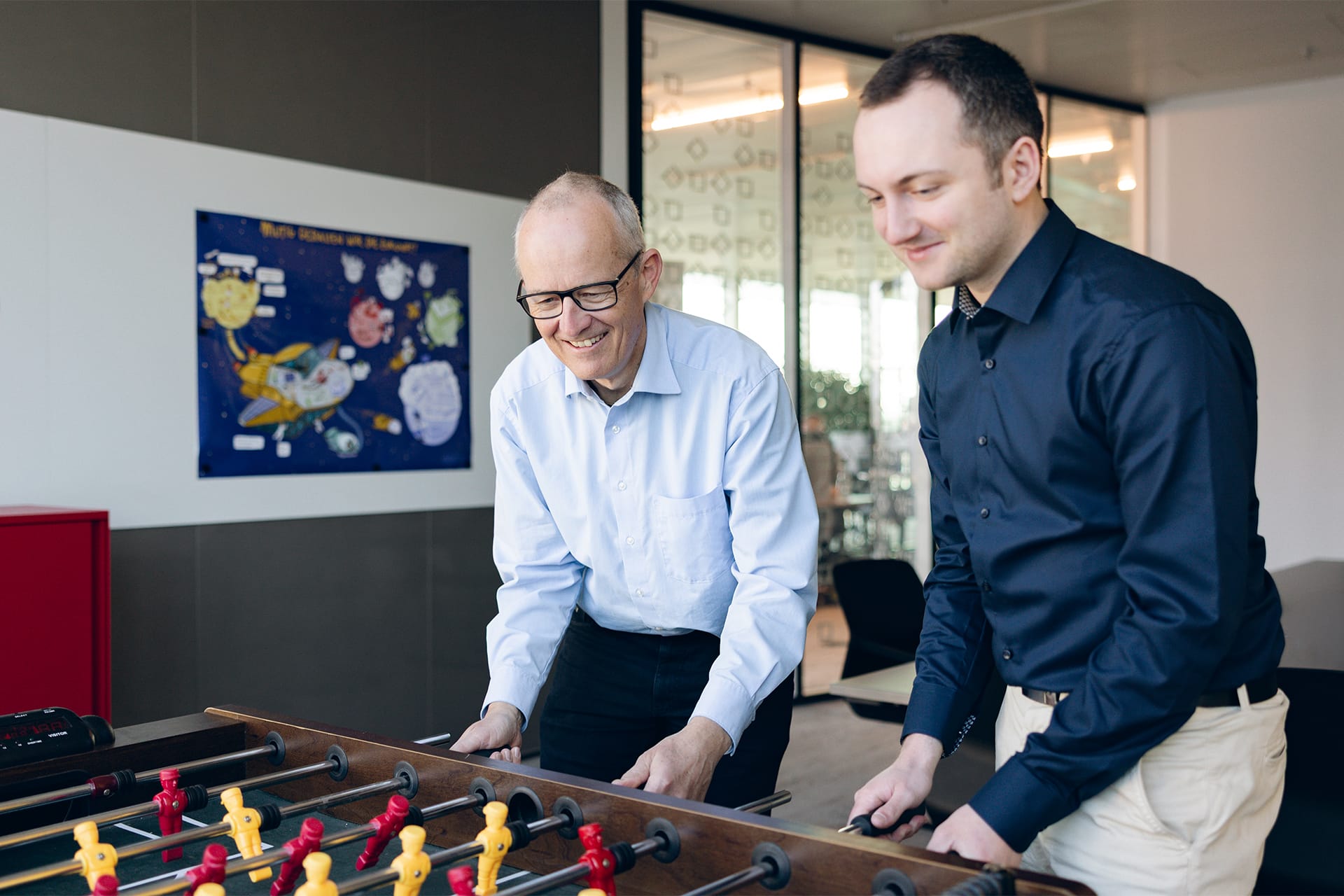 zwei SOLTIC-Mitarbeitende spielen gemeinsam am Kicker